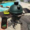 Wireless smart thermometer on a barbecue grill with smartphone app display for precise temperature monitoring.