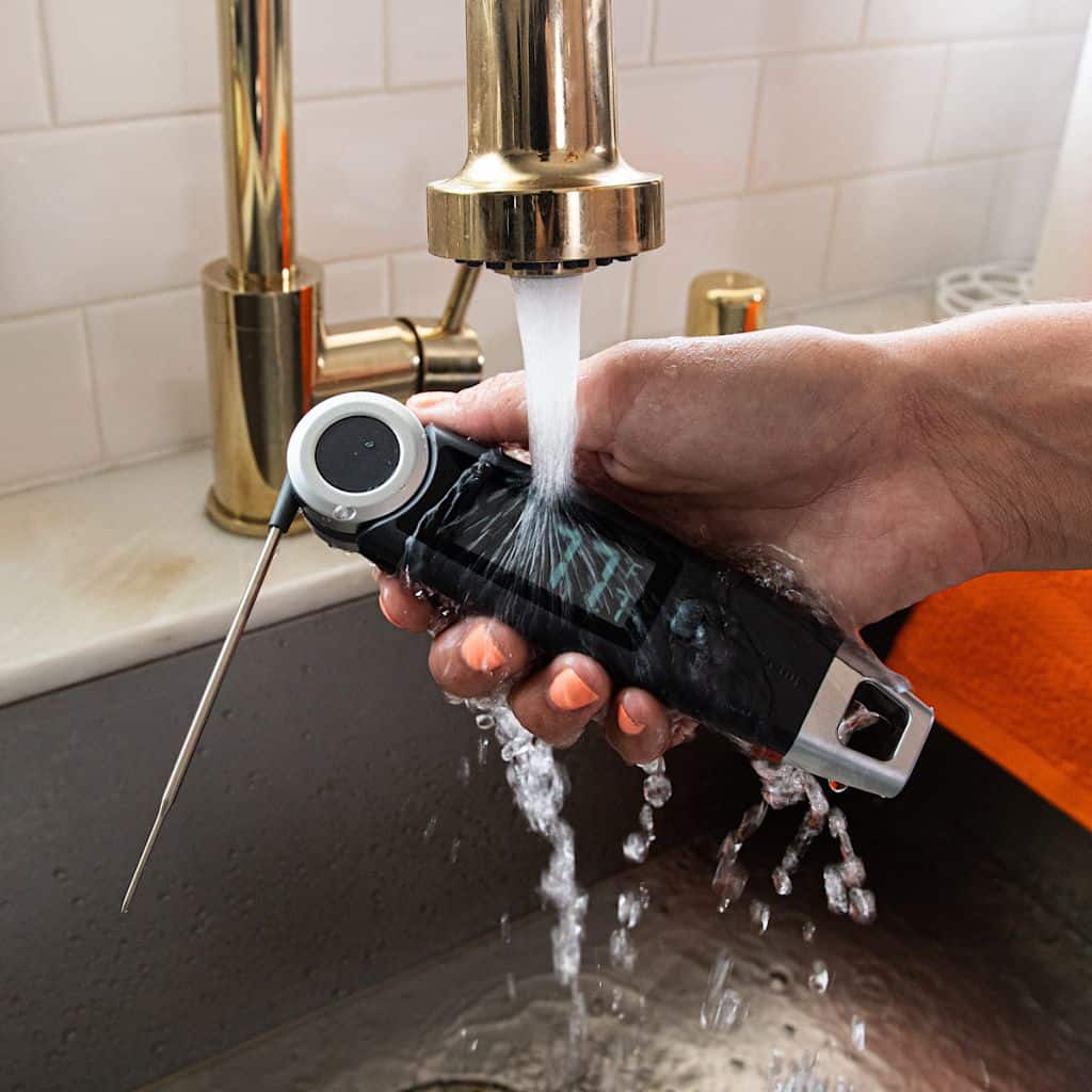 1. Waterproof digital meat thermometer under running water for food safety testing.