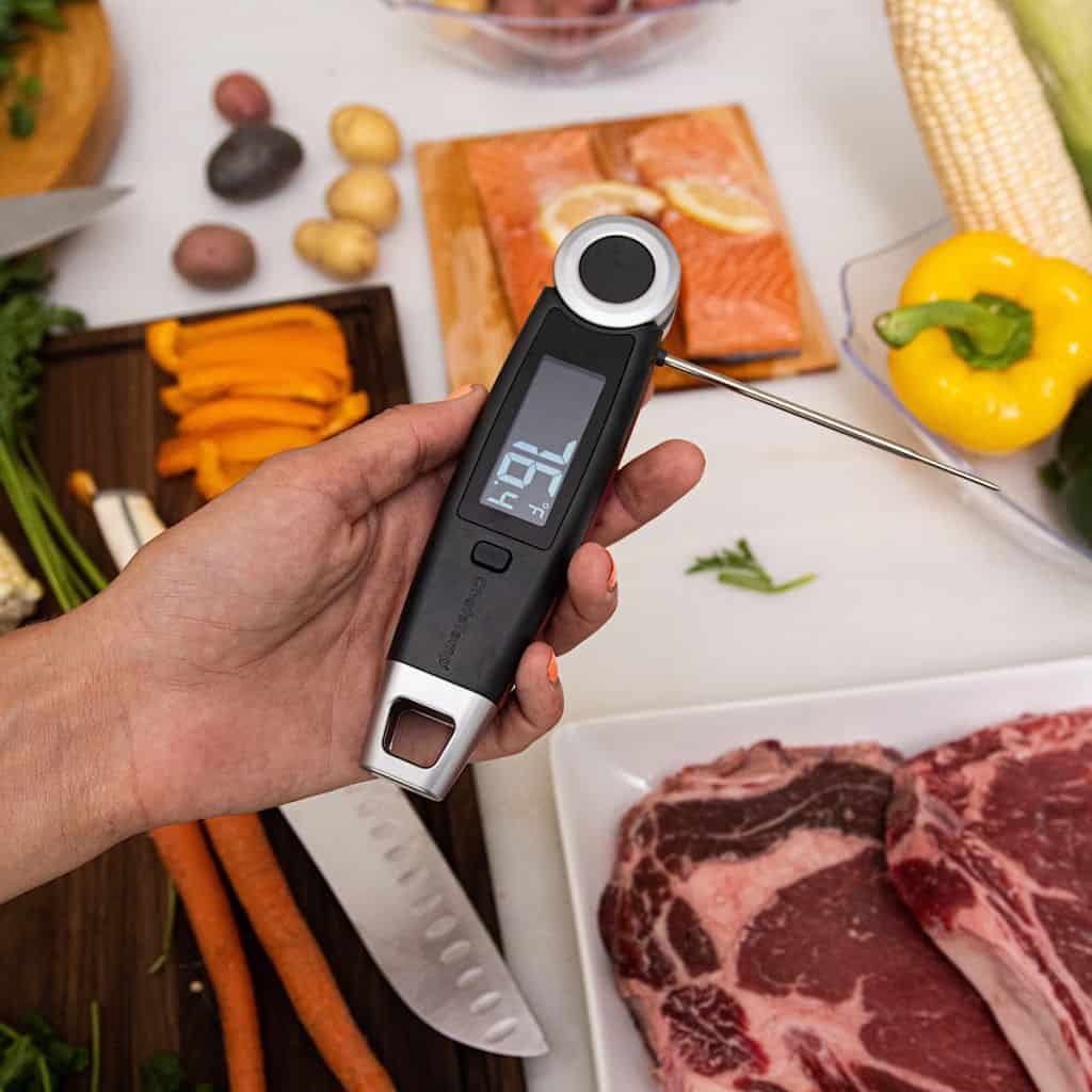 Digital food thermometer measuring meat temperature for cooking.