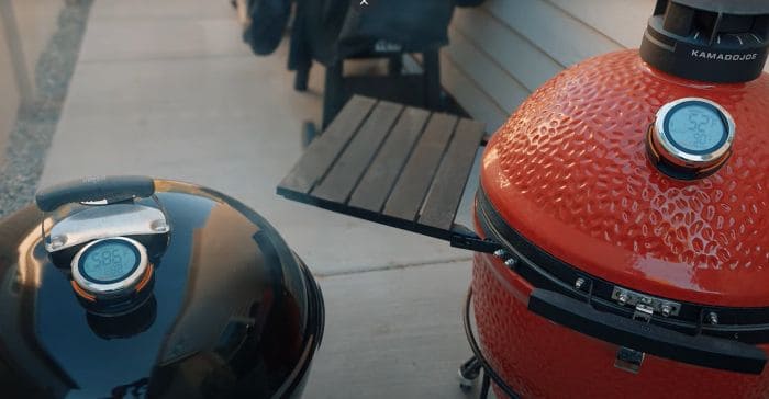 Wireless thermometer inserted into Kamado Joe grill for precise temperature monitoring.