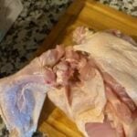 Raw chicken on a wooden cutting board ready for cooking.