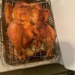 Perfectly roasted whole chicken on a grilling rack, ready to serve.