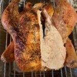 Whole roasted turkey with crispy skin and juicy meat, perfect for holiday celebrations.