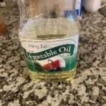 Vegetable oil in a glass jar on a kitchen countertop.